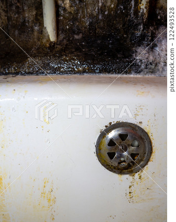 Bathroom drain dirty. Siphon element. Plumbing. Mold on bathroom enamel. Black dots of mold and yellow plaque. Requires cleaning. Before using cleaning products. 122493528
