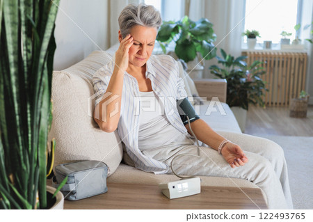 Concept health. An elderly beautiful gray-haired woman measures blood pressure 122493765