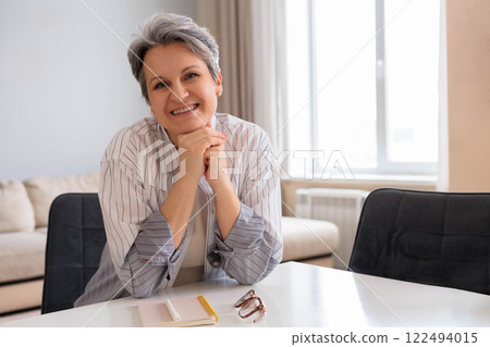 Portrait of a beautiful, well-groomed woman pensioner aged. Elderly lady with gray hair sits Portrait of a beautiful, well-groomed woman pensioner aged. Elderly lady with gray hair sits 122494015