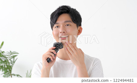 用電動剃須刀刮鬍子的男人 122494481