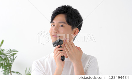 Man shaving with an electric shaver 122494484