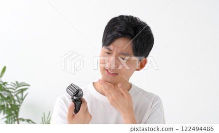 用電動剃須刀刮鬍子的男人 用電動剃須刀刮鬍子的男人 122494486