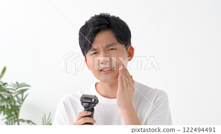 用電動剃須刀刮鬍子的男人 122494491