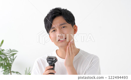 用電動剃須刀刮鬍子的男人 122494493