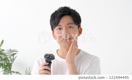 用電動剃須刀刮鬍子的男人 122494495