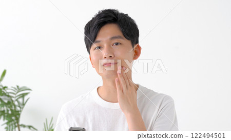 Man shaving with an electric shaver 122494501