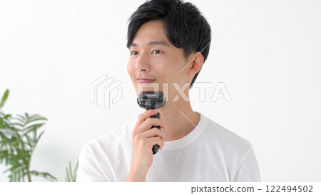 Man shaving with an electric shaver 122494502
