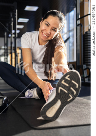 Athletic fitness Asian woman stretching body at gym enjoy physical exercise activity 122494562