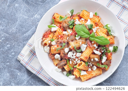 Rigatoni alla Norma pasta with eggplant, tomato, basil, ricotta salata, horizontal, top, copy space 122494626