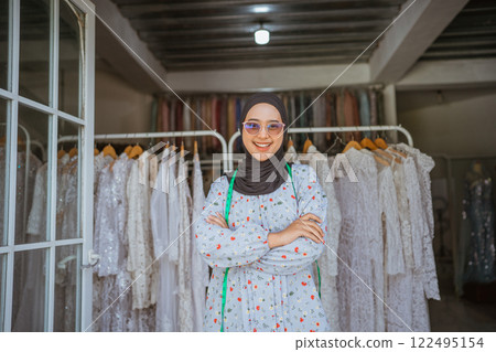 A Confident Woman Happily Poses in a Boutique Surrounded by Elegant Dresses A Confident Woman Happily Poses in a Boutique Surrounded by Elegant Dresses 122495154