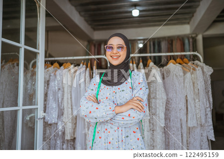 A Stylish Young Woman Posing in a Boutique Surrounded by an Elegant Dresses Background 122495159