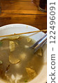 chinese soup in a bowl with chopsticks on a wooden table 122496091