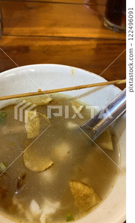 chinese soup in a bowl with chopsticks on a wooden table 122496091