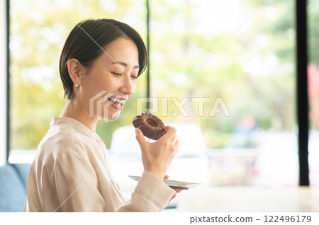 一個女人在咖啡館吃糖果 一個女人在咖啡館吃糖果 122496179