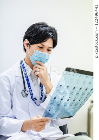 Doctor looking at MRI image at medical examination Doctor looking at MRI image at medical examination 122496443
