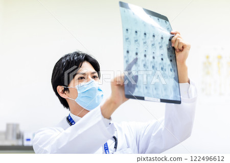 Doctor looking at MRI image at medical examination Doctor looking at MRI image at medical examination 122496612