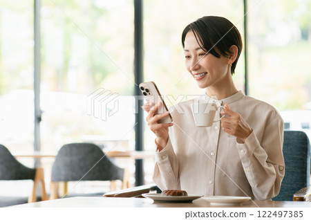 一個在咖啡館放鬆的中年婦女 一個在咖啡館放鬆的中年婦女 122497385
