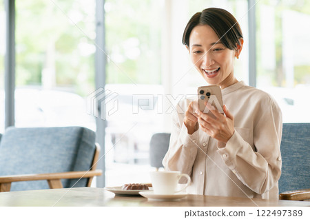 一個在咖啡館放鬆的中年婦女 一個在咖啡館放鬆的中年婦女 122497389