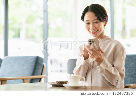 一個在咖啡館放鬆的中年婦女 一個在咖啡館放鬆的中年婦女 122497390