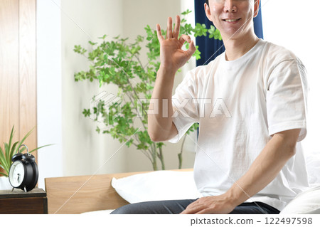 年輕亞洲男子在床上做出「OK」手勢 122497598