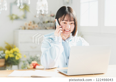A young woman teleworking in the living room A young woman teleworking in the living room 122498043