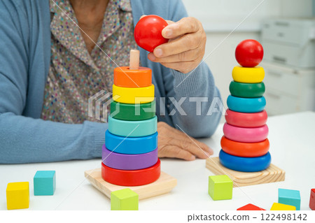Asian elderly woman playing enhancing skill board game. 122498142