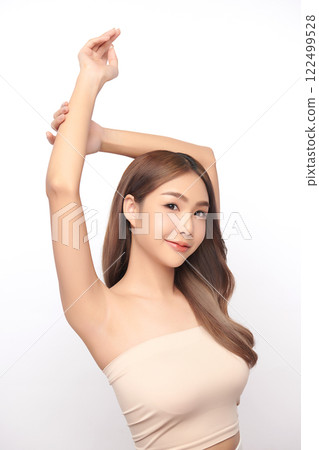 Beautiful Young Asian woman lifting hands up to show off clean and hygienic armpits or underarms on white background, Smooth armpit cleanliness and protection concept 122499528