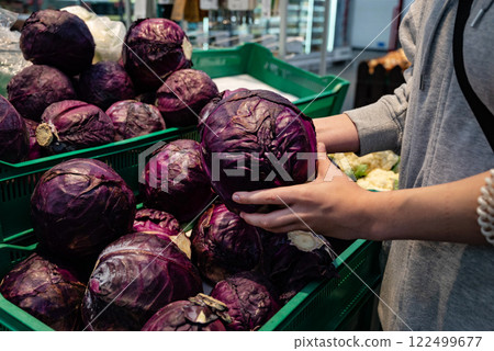 Picking fresh purple cabbage at a local market in the afternoon, showcasing vibrant produce and shopping experience Picking fresh purple cabbage at a local market in the afternoon, showcasing vibrant produce and shopping experience 122499677