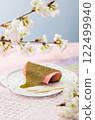 Kanto style Sakura mochi with cherry blossom branch and washi paper background 122499940