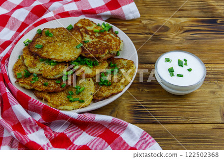 Potato pancakes with sour cream on a wooden table 122502368