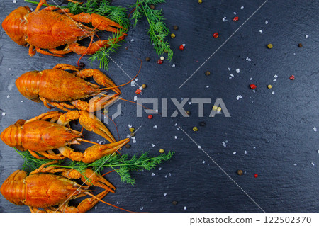 Red boiled crayfish with dill and spices on black slate background. Top view 122502370