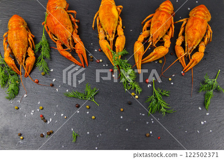 Red boiled crayfish with dill and spices on black slate background. Top view 122502371