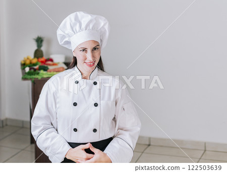 Portrait of a female nutritionist in uniform with fresh vegetables on the table, A female nutritionist with a table of vegetables, Portrait of a female chef surrounded by fresh vegetables 122503639