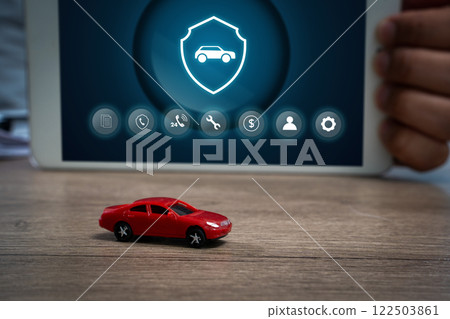 A small red toy car is on a wooden tableCar protection and safety assurance concept. A small red toy car is on a wooden tableCar protection and safety assurance concept. 122503861