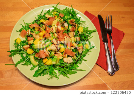 Fresh healthy salad with mango, avocado, salmon, arugula and croutons on wooden table Fresh healthy salad with mango, avocado, salmon, arugula and croutons on wooden table 122506450