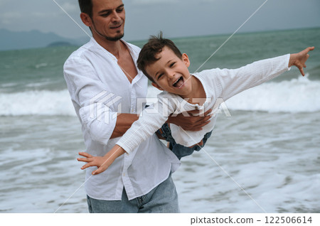 happy dad with child son playing on beach by the sea in summer on vacation 122506614