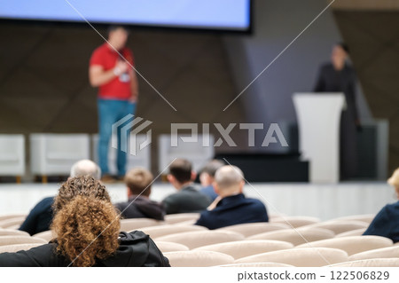 Speaker at a business conference with attentive audience members listening 122506829