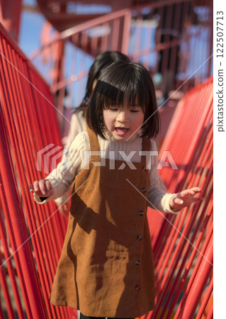 一個女孩在公園的遊樂場玩耍 一個女孩在公園的遊樂場玩耍 122507713