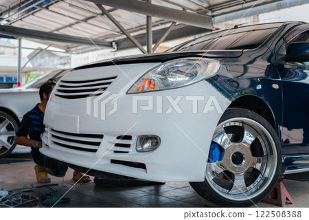 Checking car body work fiber bumper at car garage 122508388