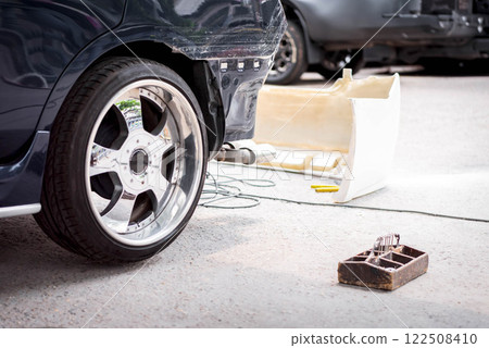 Checking car body work fiber bumper at car garage 122508410