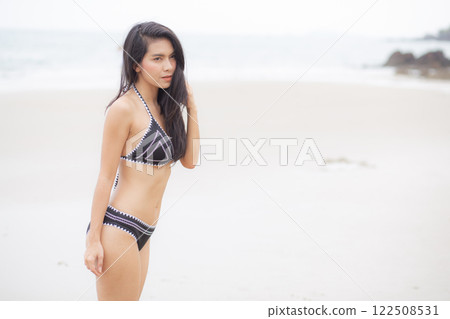 Beautiful young asian woman standing with happiness for relax on beach in tropical. 122508531