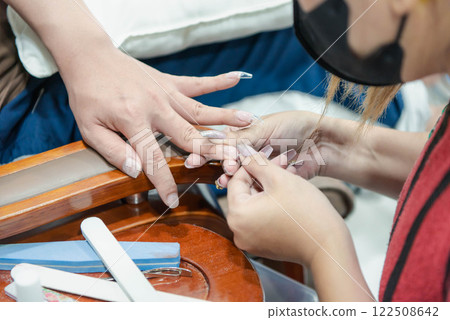 Woman (LGBTQ) do a manicure or pedicure at nails Woman (LGBTQ) do a manicure or pedicure at nails 122508642