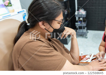 Woman (LGBTQ) do a manicure or pedicure at nails Woman (LGBTQ) do a manicure or pedicure at nails 122508645