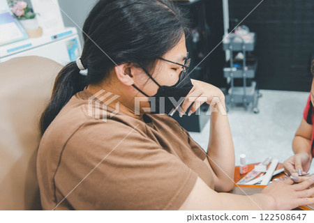 Woman (LGBTQ) do a manicure or pedicure at nails Woman (LGBTQ) do a manicure or pedicure at nails 122508647