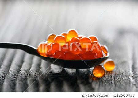 Close up of red caviar in a metal spoon Close up of red caviar in a metal spoon 122509435