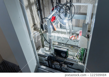 This is an interior view of an elevator shaft with essential mechanical parts and wiring 122509484