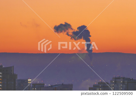 Dramatic and Stunning Sunset with Smoke Streaking Across the Cityscape Beneath the Horizon 122509500