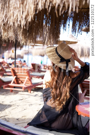 Woman in straw hat relaxing at tropical beach  122510172
