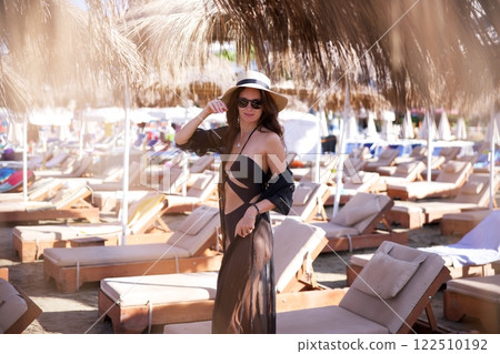Elegant woman in black beachwear at luxury resort  122510192