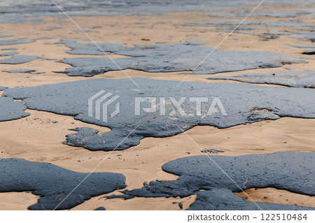 Oil spill in ocean coastline after a tanker wreck. Fuel oil leak and polluted ocean beach, ecological catastrophe Oil spill in ocean coastline after a tanker wreck. Fuel oil leak and polluted ocean beach, ecological catastrophe 122510484